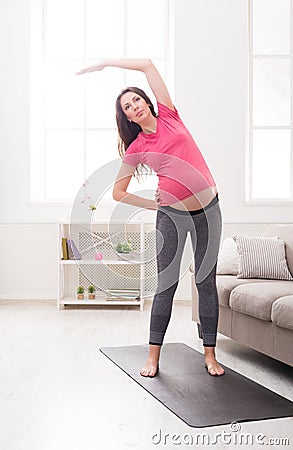 Pregnant woman warmup stretching training indoors Stock Photo