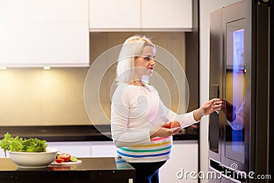 Pregnant woman in white kitchen. Healthy pregnancy Stock Photo