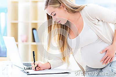 Pregnant woman at work Stock Photo