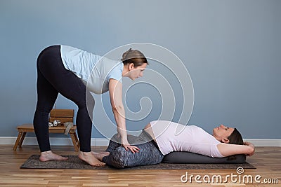 Pregnant woman doing prenatal yoga in Baddha Konasana or Purna Titli Stock Photo