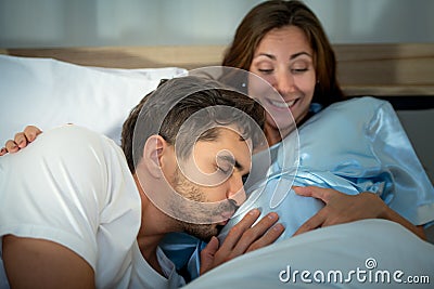 Pregnant woman with husband in bedroom with the atmosphere of having fun talking Stock Photo