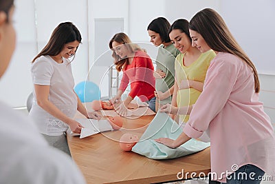 Pregnant women learning how to swaddle baby at courses for expectant mothers indoors Stock Photo