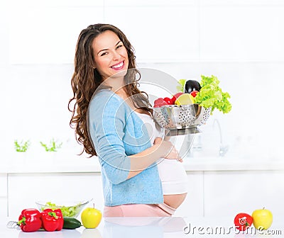 Pregnant young woman cooking vegetables Stock Photo