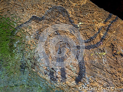 Prehistoric art of mammoth in sandstone cave. Spotlight shines on historical painting Stock Photo