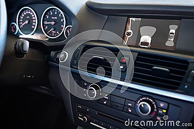 Premium car interior backup parking assistant system with sensors on screen with out of focus dashboard and steering wheel. Driver Stock Photo