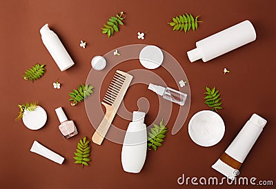 Premium skin care cosmetics, perfume on brown rustic background with green leaves. Stock Photo
