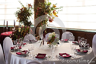 Banquet round tables decorated with a bouquet in the center of the tables Stock Photo