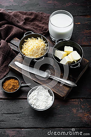 Preparation of bechamel cheese white sauce, on old dark wooden table background Stock Photo