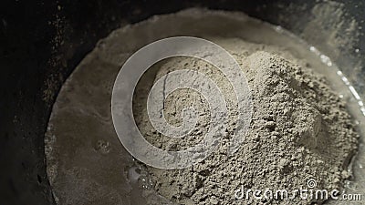 Preparation Of Cement Mix For Use In Tile Laying. A close-up of a solution in a bucket. Stock Photo