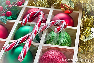 Preparation for Christmas: festive balls and candy cane in wooden box, light white frame Stock Photo