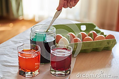 preparation for the Easter holiday, coloring eggs at home, tissue with spoons Stock Photo