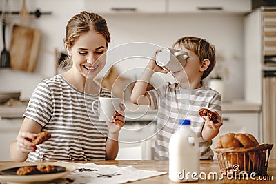 Preparation of family breakfast. mother and child son cut bread and eat cookies with milk in morning Stock Photo