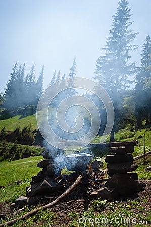 Tourist camping with a fire in the mountains Stock Photo