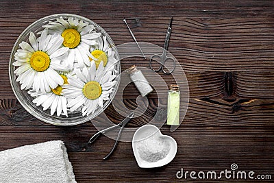 Preparation for manicure with chamomile on dark wooden background top view space for text Stock Photo