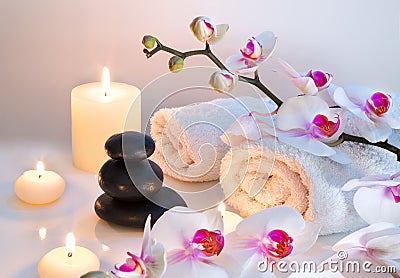 Preparation for massage with two towels, stones, candles and orchid Stock Photo