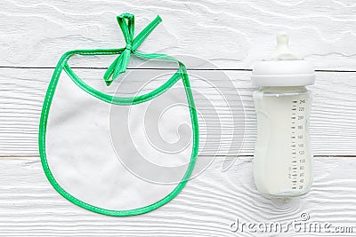 Preparation of mixture baby feeding with infant formula powdered milk in bottle with bib on white background top view Stock Photo