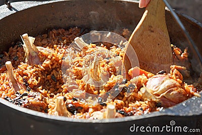 Preparation of pilaf on fire. Tourist bowler with food on bonfire, cooking in the hike, outdoor. Stock Photo