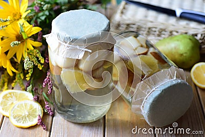 Preparation for winter: sweet compote of pears in glass jars on a white table Stock Photo