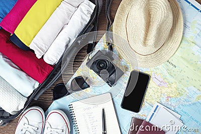 Prepare accessories and travel items, for new journey, packing clothes in suitcase bag on wooden board, flat lay, top view Stock Photo