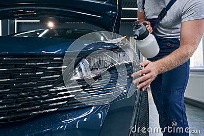 Prepare car headlight for protective film application closeup Stock Photo