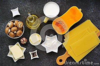 Prepared ingredients for cooking lasagna with pumpkin and mushrooms on an dark concrete background. Lasagna recipes Stock Photo