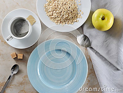 Preparing for Breakfast - tea bags and oatmeal with butter, yell Stock Photo