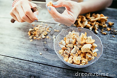Farm holidays: Woman is preparing delicious chanterelle mushrooms on an old rustic wooden table Stock Photo