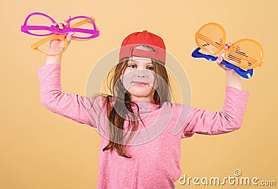 Preparing a cool party. Fashionable party girl. Adorable party girl holding fancy glasses. Cute small child choosing Stock Photo