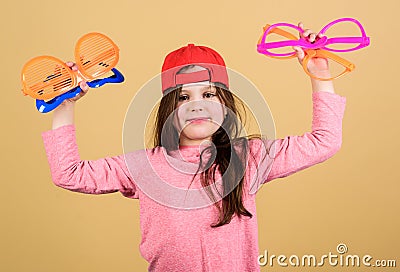 Preparing a cool party. Fashionable party girl. Adorable party girl holding fancy glasses. Cute small child choosing Stock Photo