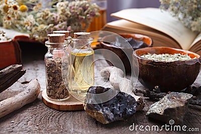 Preparing cosmetic black mud mask in ceramic bowl on vintage wooden background. Front view of facial clay emulsion on table with Stock Photo