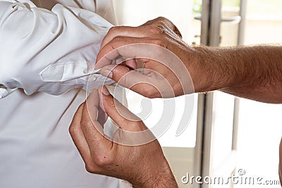 Preparing the groom on the wedding day puts on cufflinks Stock Photo