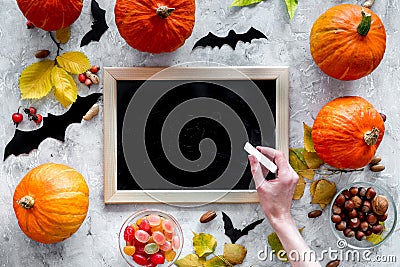 Preparing for halloween. Black desk for notes among pumpkins and bats on grey background top view mockup Stock Photo