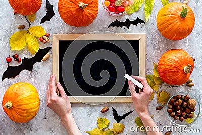 Preparing for halloween. Black desk for notes among pumpkins and bats on grey background top view mockup Stock Photo