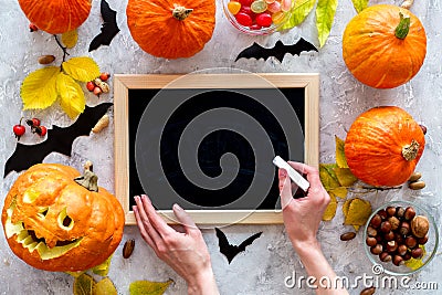 Preparing for halloween. Pumpkin head near pumpkins and black desk for notes on grey background top view mockup Stock Photo