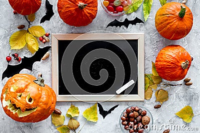 Preparing for halloween. Pumpkin head near pumpkins and black desk for notes on grey background top view mockup Stock Photo