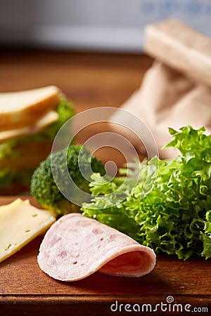 Preparing ham sandwiches for scool lunchbox on wooden background, close up. Stock Photo