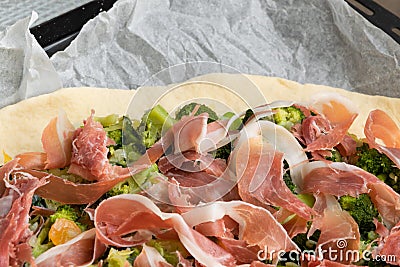 Preparing homemade pizza with vegetables and raw ham Stock Photo