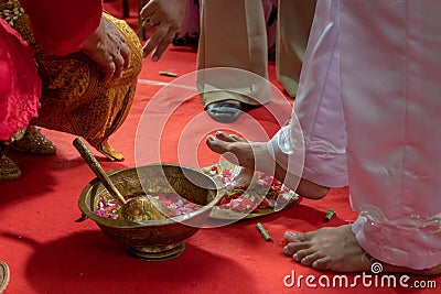 Preparing for Ngidak tagan or Nincak ndog, the ritual of stepping on raw chicken eggs by the groom at a traditional Javanese weddi Stock Photo