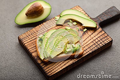 Preparing sandwiches with avocado, healthy organic food. Sliced avocado on toast. Stock Photo