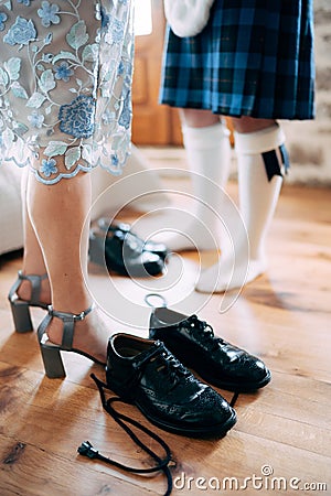 Preparing for a scottish wedding. Man in a kilt and sporran stands next to woman in a skirt and high-heeled shoes. There Stock Photo