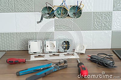 Preparing to install an electrical outlet. Closeup of professional electrician tools and electrical outlets. Renovation and Stock Photo