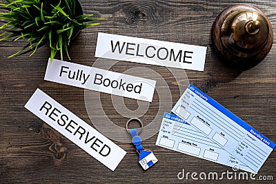 Preparing to trip. Book hotel and tickets. Tickets near service bell, bank card on dark wooden table top view Stock Photo