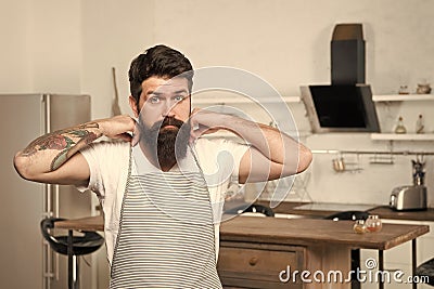 Preparing traditional cuisine. Serious cook before preparing delicious cuisine in kitchen. Bearded chef wearing apron in Stock Photo