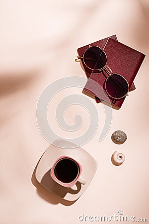 Preparing for the trip. Passports, sunglasses, seashells and a cup of coffee on a pink background in the shadows from tree leaves Stock Photo