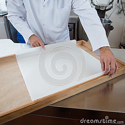 Preparing wooden frame with rice paper as mold for nougat Stock Photo