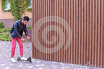 Prepossessing Arabian Masculine Yound Guy Rides Scooter, Fun and Stock Photo