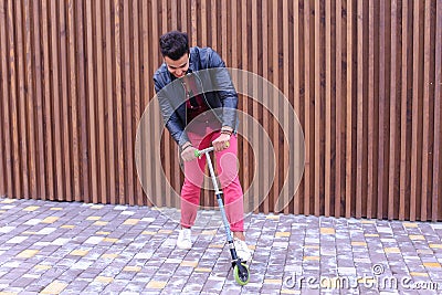 Prepossessing Arabian Masculine Yound Guy Rides Scooter, Fun and Stock Photo