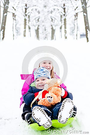 Preschool age siblings go on bobsled in winter time Stock Photo