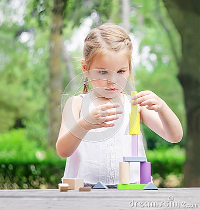 Preschool child build a tower of colorful wooden building blocks Stock Photo