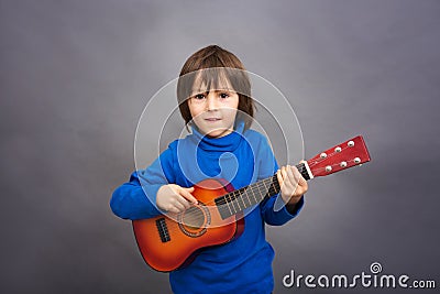 Preschool child, playing little guitar, image Stock Photo